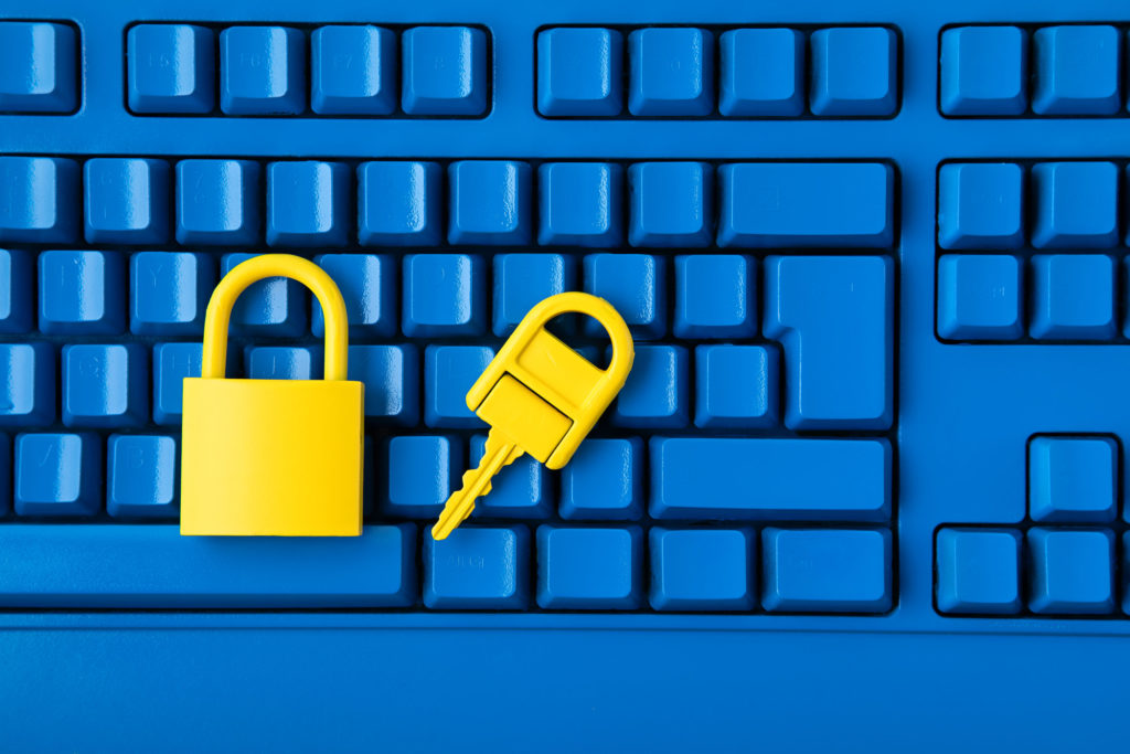 Yellow padlock and key and blue keyboard. Computer